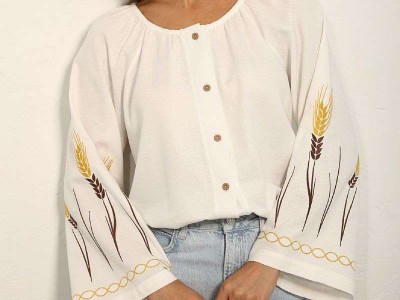 What do the wheat spikes on the embroidered shirt symbolize?