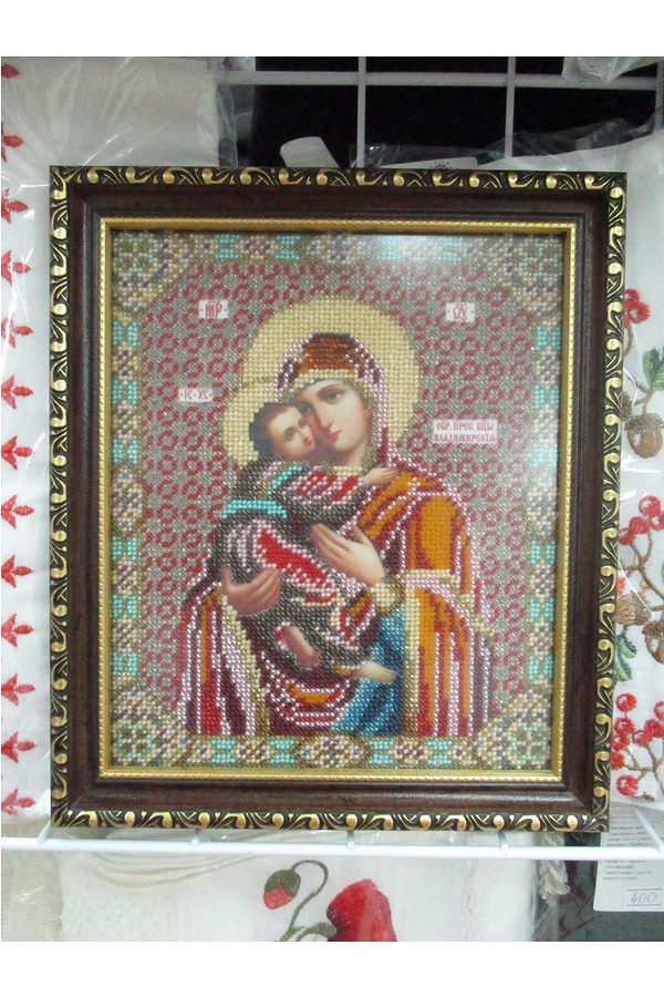 The icon of the Mother of God is embroidered with beads and a frame