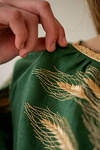 Green women's embroidered shirt with ears of wheat in a bouquet.