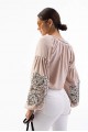 Women's embroidered blouse light beige with smooth flowers on the sleeves. Spring.