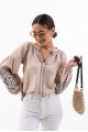 Women's embroidered blouse light beige with smooth flowers on the sleeves. Spring.